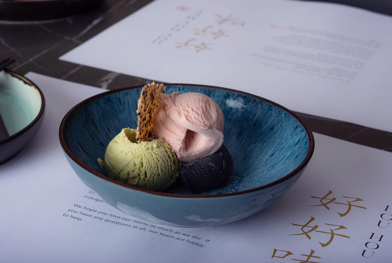 Close up of printed menus at HouHouMei with a beautifully arranged ice cream dessert on top