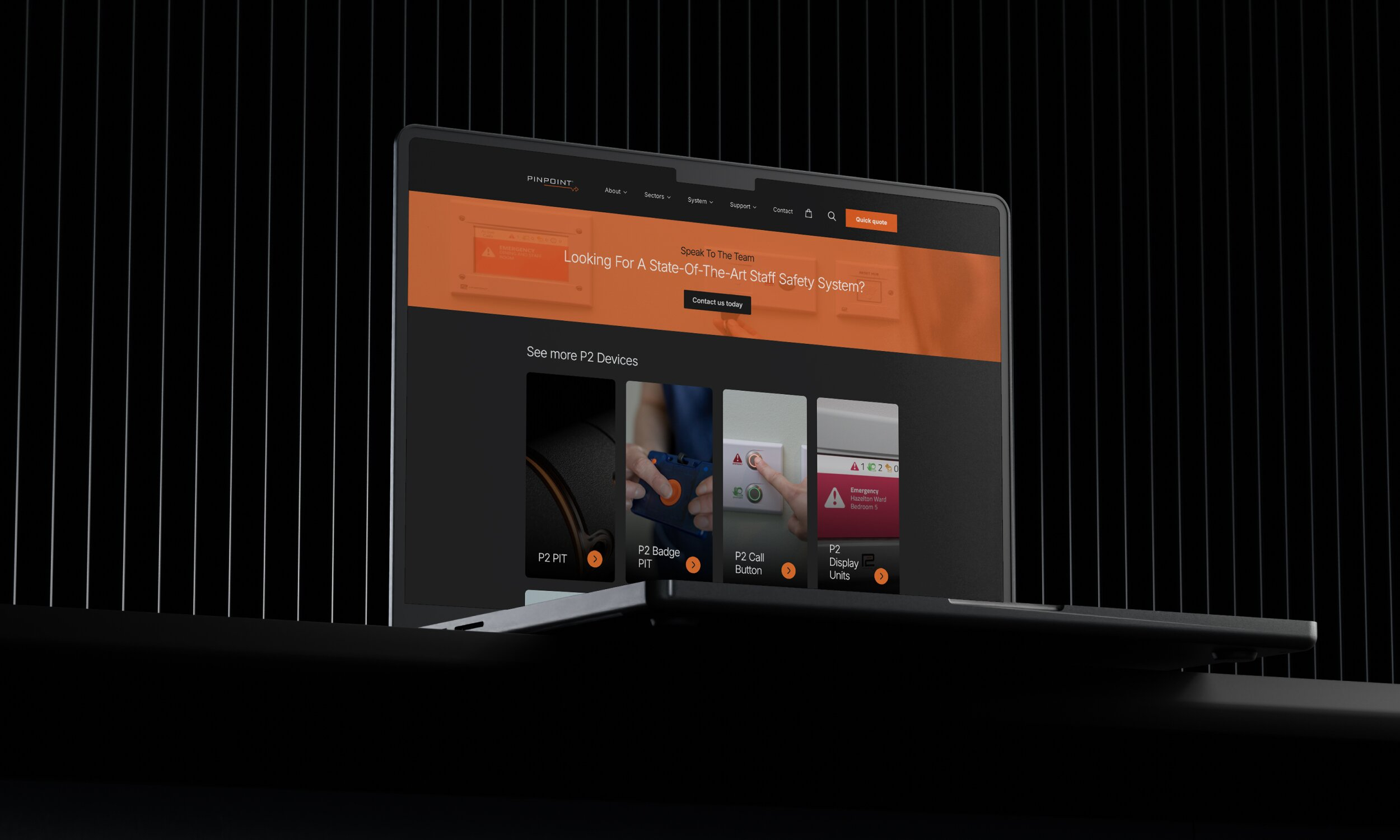 Laptop displaying Pinpoint Ltd staff safety systems website with P2 device product grid on dark background